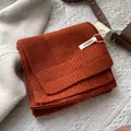 Detalle de una bufanda de 100% lana pura en color naranja con tejido de punto fino - Rojo Anaranjado