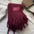 Detailed view of burgundy wool scarf with thick tassels and premium brand label texture - 180*30cm / Ancorra Red