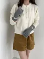 Détail de gants en tricot gris avec poignets côtelés et logo rond sur le mannequin - Gris clair