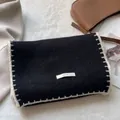 Dettaglio borsa in maglia nera con cuciture a contrasto bianche ed etichetta tessuta - Nero
