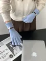 Détail de gants en tricot bleu clair avec texture côtelée et étiquette de poignet - Bleu clair