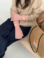 Gros plan de gants en tricot rose avec texture côtelée et logo sur le poignet - Rose