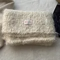Close-up of cream wool scarf showing fluffy texture and pink BOWLOW logo patch - Off White