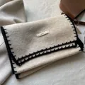 Dettaglio ravvicinato della sciarpa in maglia beige con bordo a sopraggitto e logo - Bianco Sporco