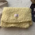 Detail shot of the creamy yellow plush texture and BOWLOW label on the winter handbag - Yellow