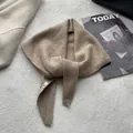 Détail d'un foulard triangle en tricot kaki avec étiquette de marque et texture - 100x30cm / Chameau