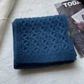 Detail of 100% wool knitted scarf with blue cable texture and authentic label - Navy Blue