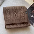 Close-up of 100% wool knit scarf in dark coffee showing detailed cable knit pattern - Coffee