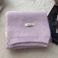 Detail showing soft lavender knit wool scarf texture with brand tag and metal letter B charm - Light Purple