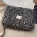Close-up of soft grey plush scarf material with a colorful BOWLOW woven brand label - Gray