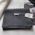Close-up of dark grey 100% pure wool scarf texture with handmade brand labels - Gray