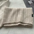 Detailed close-up showing 100% pure wool washing label on cable knit winter scarf - Off White