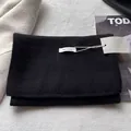 Detail shot of black 100% wool scarf showing high-quality knit texture and product tag - Black