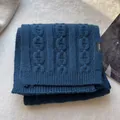 Detailed view of dark blue 100% wool scarf with cable-knit texture and material label - Navy Blue
