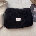 Close-up of black fluffy wool shawl with rainbow BOWLOW label on soft background - Black