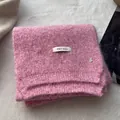 Detail of pink knitted wool scarf with ERET WOOL fabric label and silver metal B charm - Cranberry