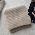 Detailaufnahme des Strickschals aus 100% Wolle mit Textur und Materialetikett - Gebrochenes Weiß