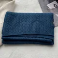 Dettaglio sciarpa blu navy 100% lana con trama a trecce ed etichetta del materiale - Blu navy