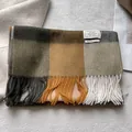 Close-up of a 100% wool scarf featuring a large plaid pattern and fringe detailing - 180x30cm / Dark Green Orange Beige