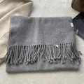 Detailed macro view of 100% pure wool scarf texture with fringe and care label - Space Gray