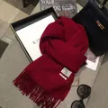 Detailed macro view of 100% pure wool red scarf with fringe and white embroidered label - 180*30cm / Ancorra Red