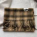 Detail view of the 100% virgin wool tag and soft fringe on the plaid winter scarf - 180x30cm / Earth Yellow Plaid