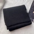 Detail showing 100% wool label on premium black ribbed knit scarf with texture - Black