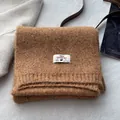 Detailed view of brown wool blend knit scarf with ribbed edges and luxury fabric label - Creamy Yellow