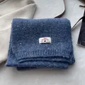 Detailed texture of thick sea salt blue wool blend knitted scarf with premium brand tag - Blue
