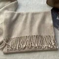 Detail of 100% pure wool scarf showing woven twill texture and classic fringe edges - Creamy White