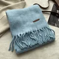 Détail d'une écharpe bleu clair avec texture brossée douce et finitions à franges - Bleu Sel de Mer