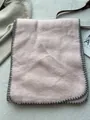 Detailaufnahme des rosa Wollschals mit grauer Kettelnaht und weicher Texturierung - 180*60cm / Rosa