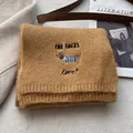 Detail of dachshund embroidery on brown knit scarf featuring one bagel and love text - Ginger Yellow