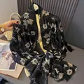 Detail of black cotton-linen scarf featuring white floral prints and fringed edges - Black