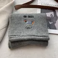 Detailed close-up of gray knitted scarf featuring a brown dachshund dog embroidery - Dark Gray