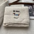 Detail of oatmeal knit scarf with cute dachshund embroidery and soft wool texture - Oatmeal