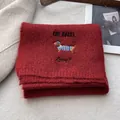 Detail of red knit scarf with dachshund embroidery and ONE BAGEL lettering text - Red