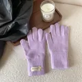 Detailed close-up of light purple knitted glove with thick ribbed cuff on wooden tray - Lavender