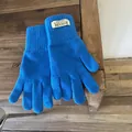 Close-up of royal blue knitted gloves featuring ribbed cuffs and a sewn-in label detail - Sea Salt Blue