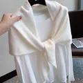 Detail eines weichen weißen Strickschals aus Wolle mit minimalistischem Knotendesign - Elfenbein