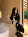 Nahaufnahme eines kontrastierenden Strickschals mit beigem Rand über einem Kleid - Schwarz Khaki Rand