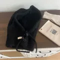 Detail of black fleece balaclava with buttons and drawstrings on wooden surface - Black