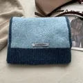 Dettaglio di sciarpa in lana lavorata a maglia blu e bianca con etichetta logo - Blu Acqua & Blu Lago