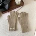 Close-up of khaki knitted winter gloves with ribbed cuffs and branded fabric label detail - Khaki