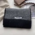 Dettaglio di sciarpa in maglia misto lana con patchwork grigio e nero ed etichetta - Grigio & Nero