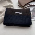Dettaglio di sciarpa in maglia a coste bicolore con etichetta e trama spessa - Blu Navy & Caffè