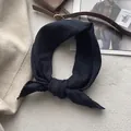Primo piano di un foulard in cotone blu navy con bordi in pizzo su sfondo beige testurizzato - Blu