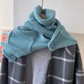Détail d'un tour de cou en laine tricotée bleu clair avec texture côtelée et bouton - Bleu Sel de Mer