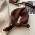 Dettaglio del foulard in cotone caramello con pizzo all'uncinetto raffinato - caffè