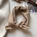 Dettaglio di un foulard in cotone marrone chiaro con bordo in pizzo su un tappeto morbido - Albicocca Tè al Latte